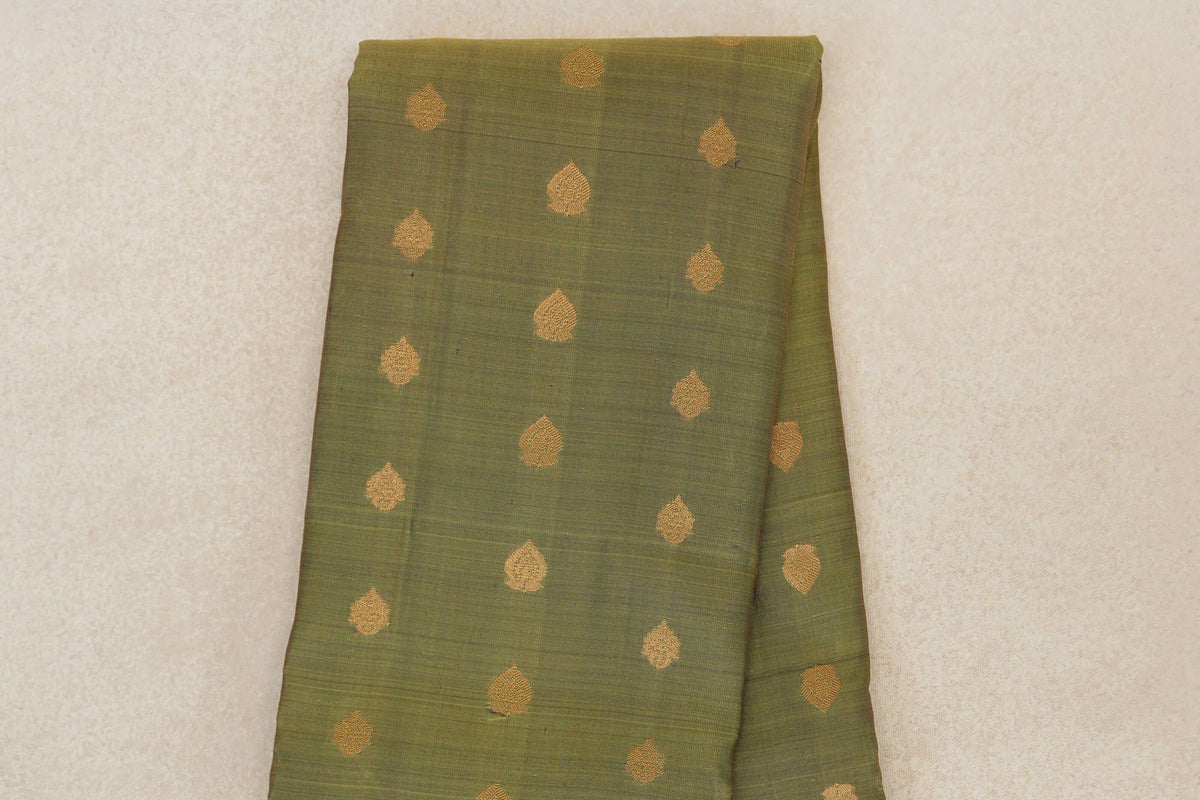 Folded olive green Kanchipuram silk saree body with evenly spaced small gold leaf-shaped motifs.