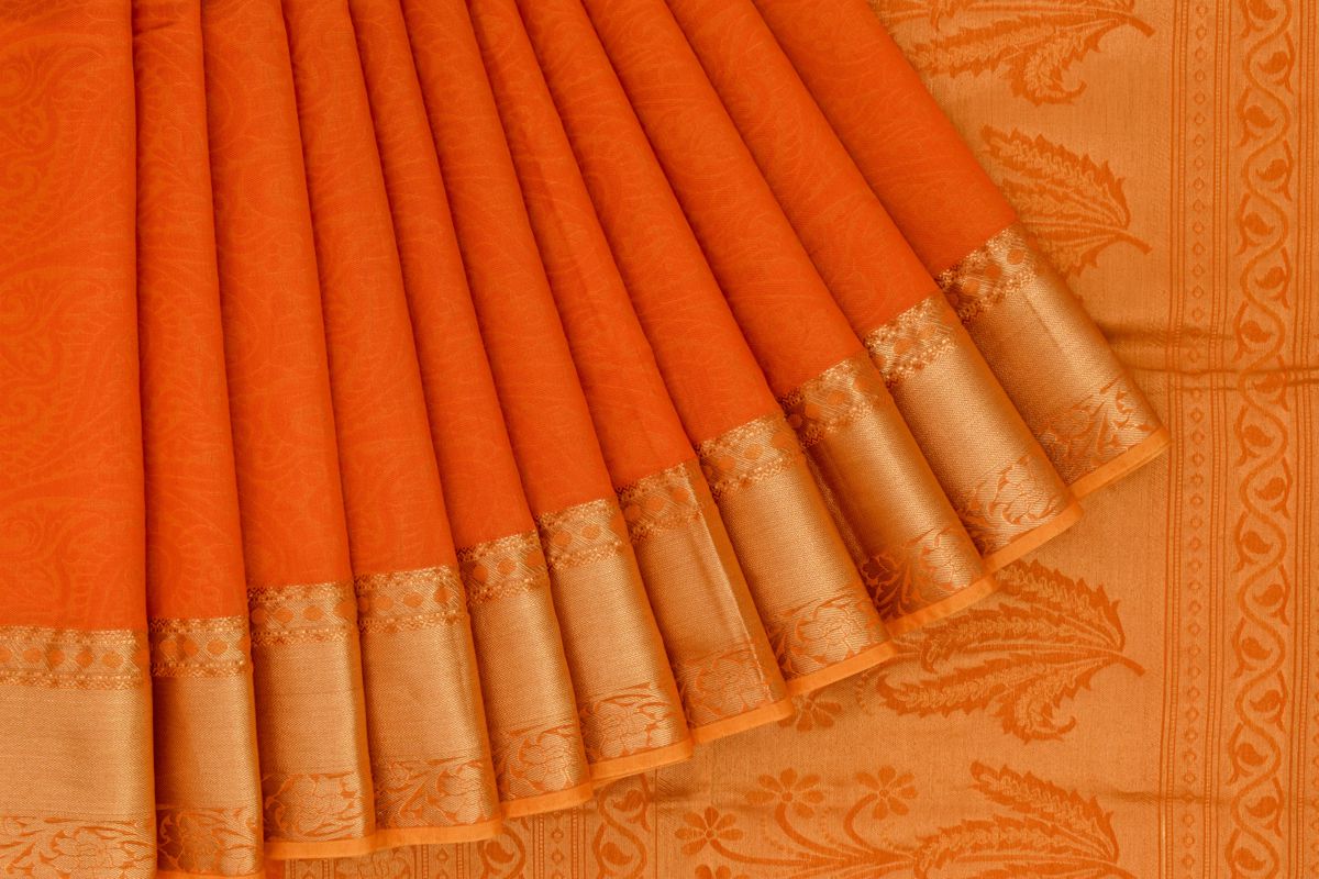 silk cotton saree with orange body and mustard border, featuring floral details on the border.