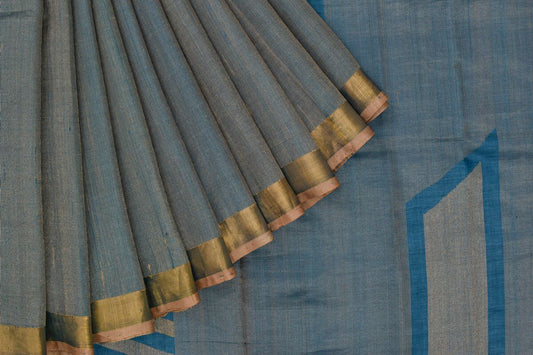 tussar silk saree with blue body and beige border, showing the texture and design detail.